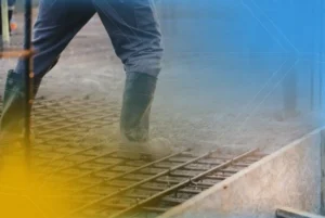 Trabalhador ajustando a base de concreto, um cuidado essencial durante a concretagem em dias frios